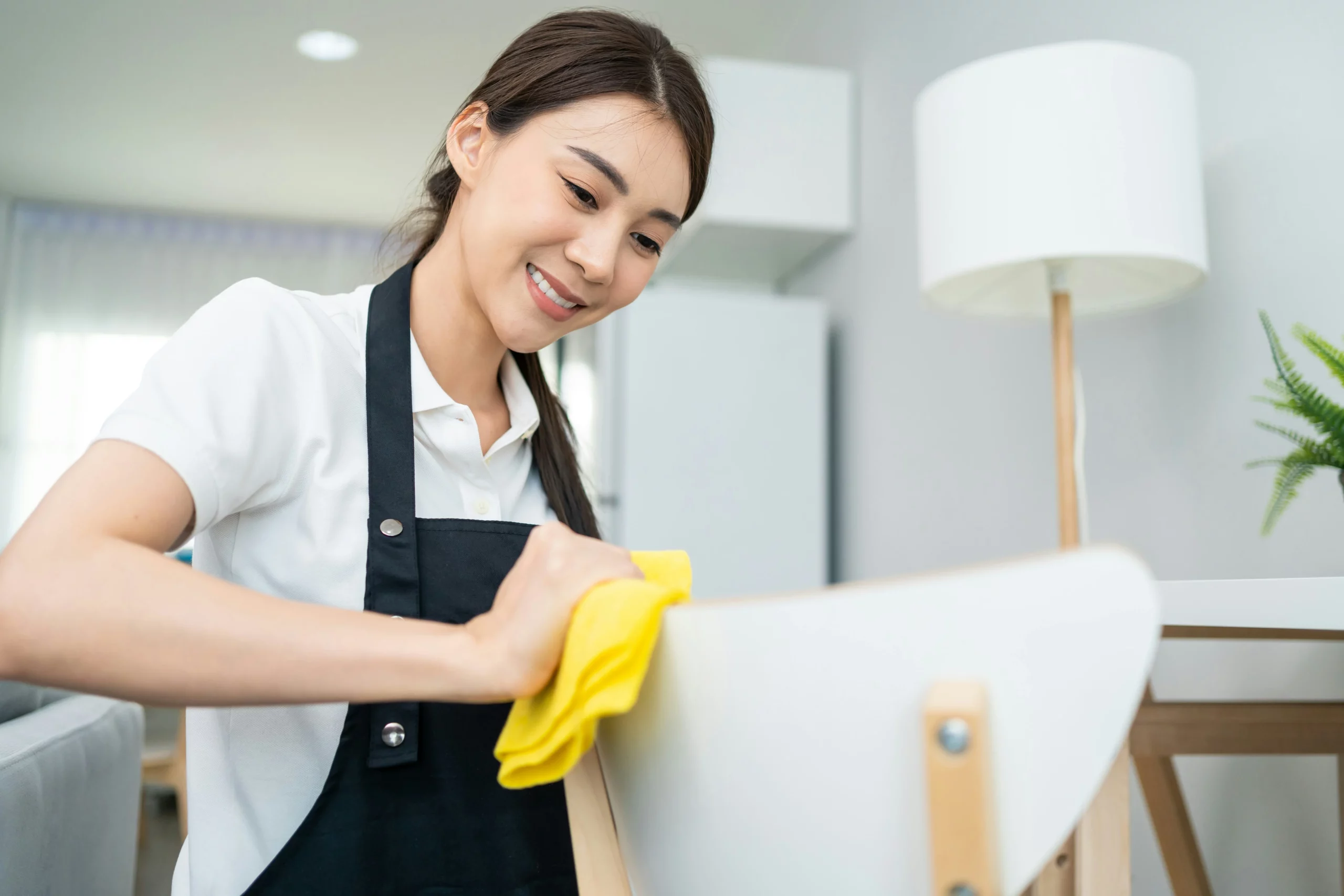 Professional cleaner wiping furniture during house cleaning Tucson AZ services