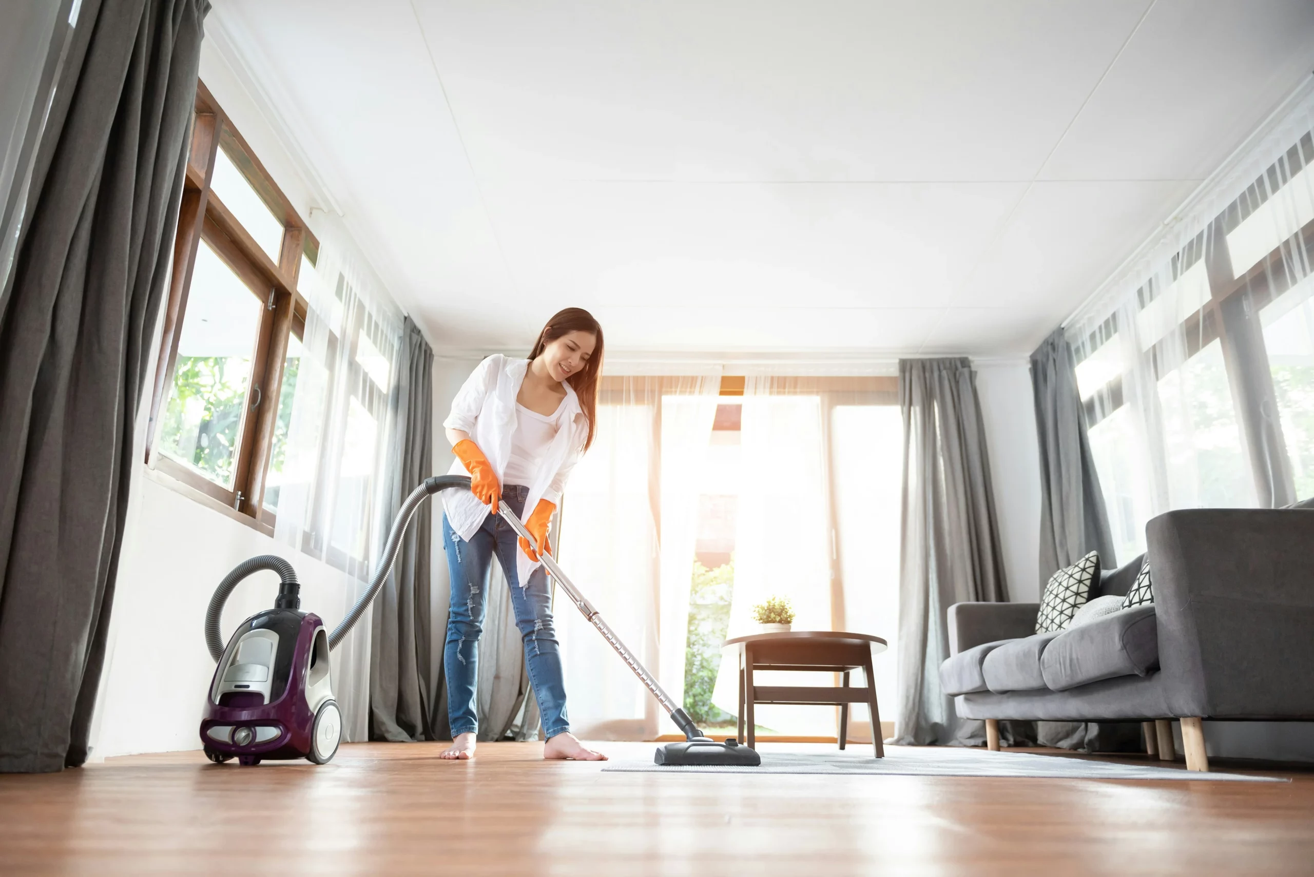 Woman vacuuming living room as part of house cleaning Tucson AZ services