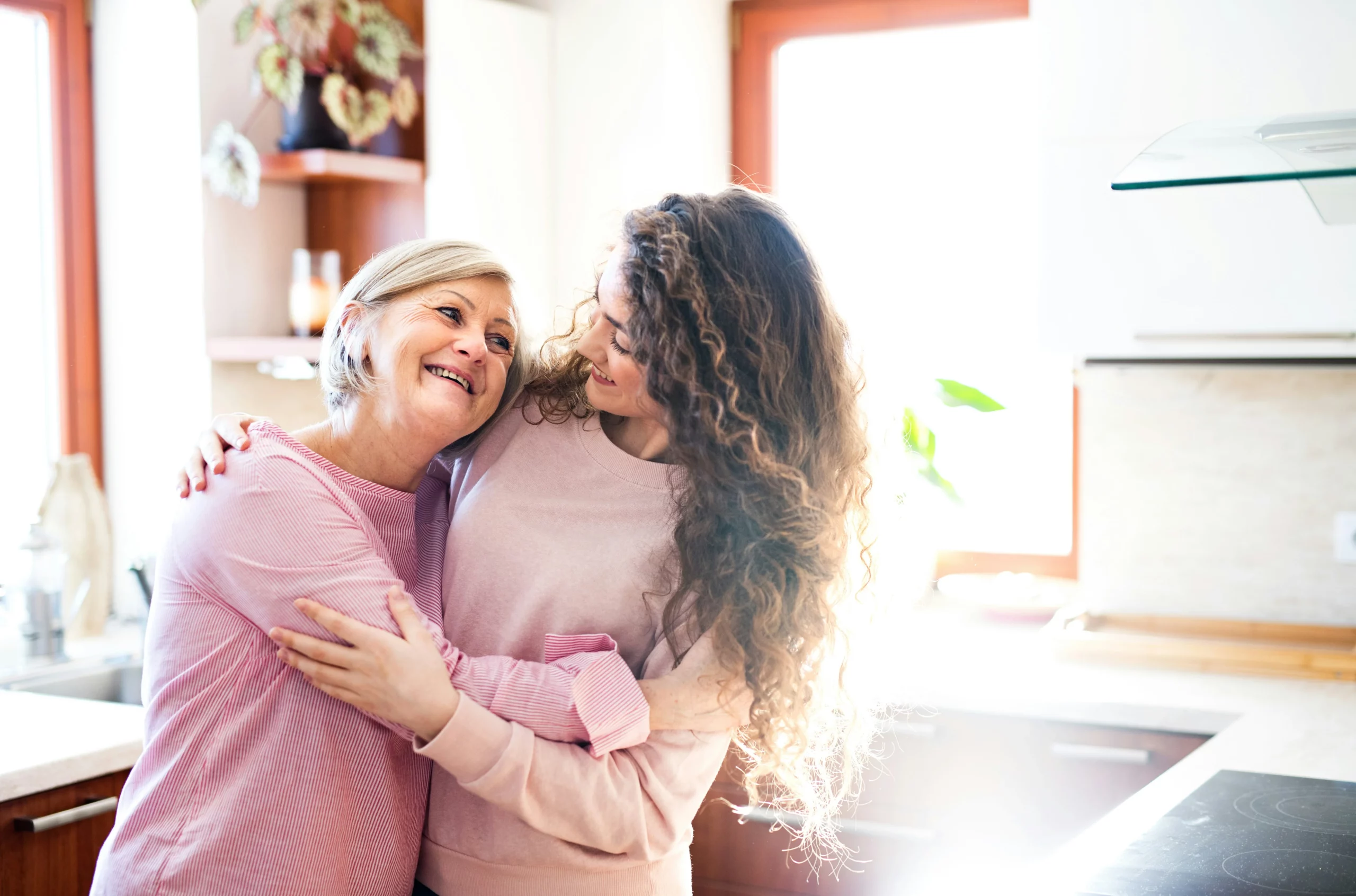 image of elderly mother and daughter hugging in clean house