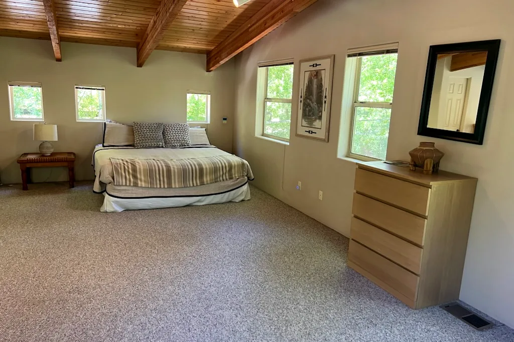 Clean carpeted bedroom with wood ceiling after a house cleaning in Arizona