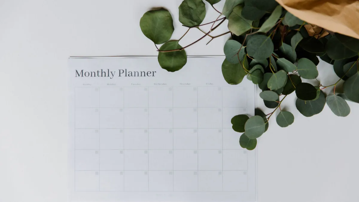 Blank monthly planner on a white desk