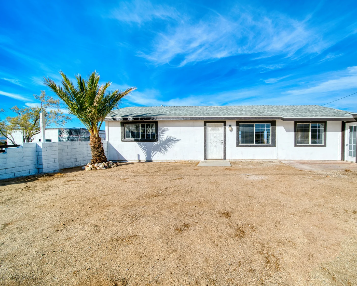 Single-story home with a palm tree and desert yard