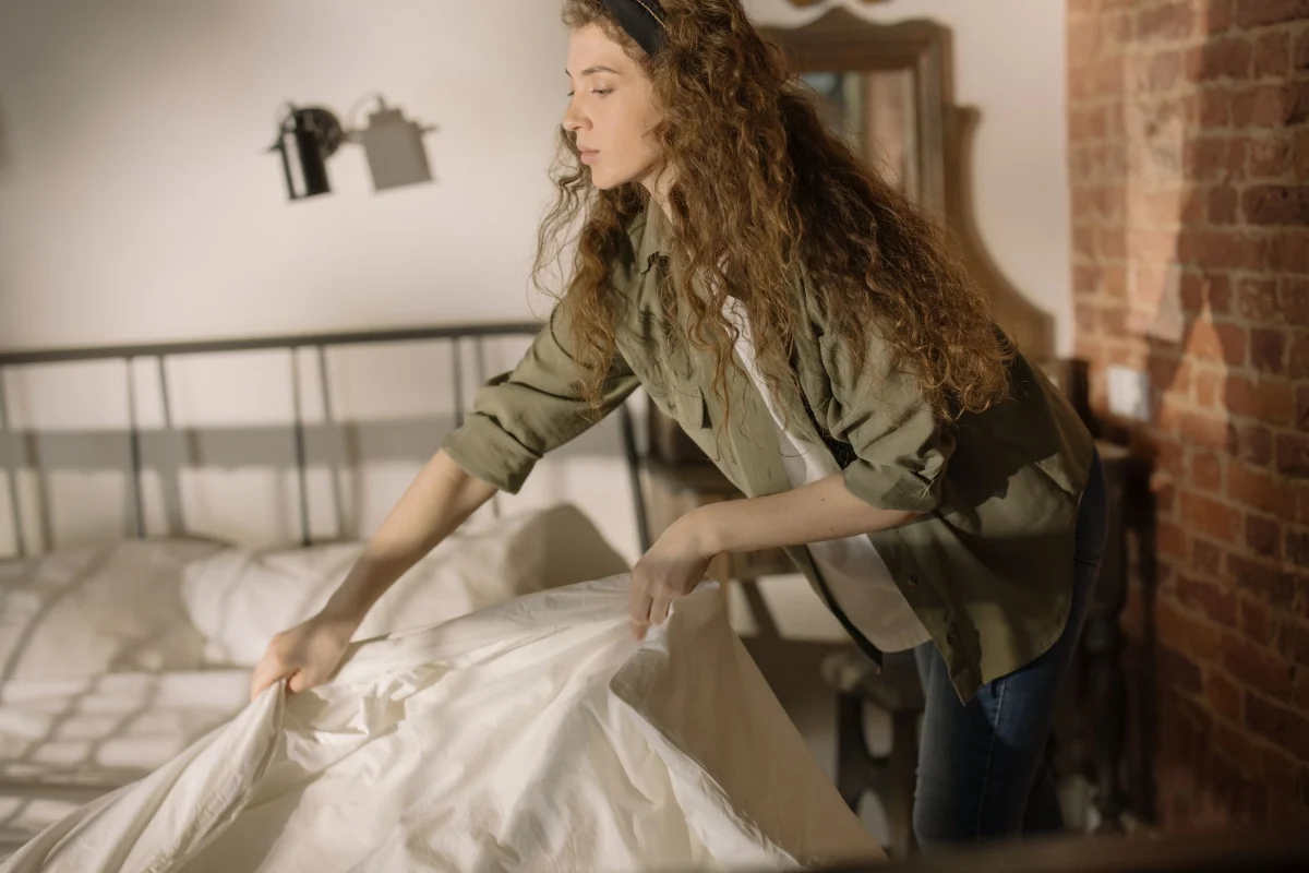 Cleaner making the bed during a rental turnover