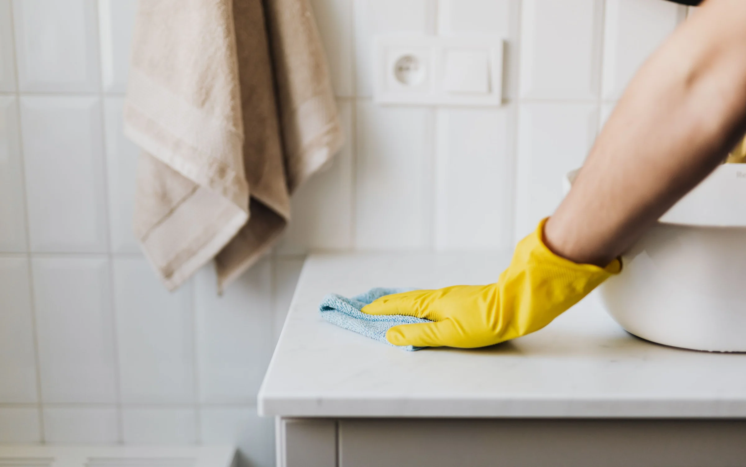 Gloved hand wiping a bathroom counter