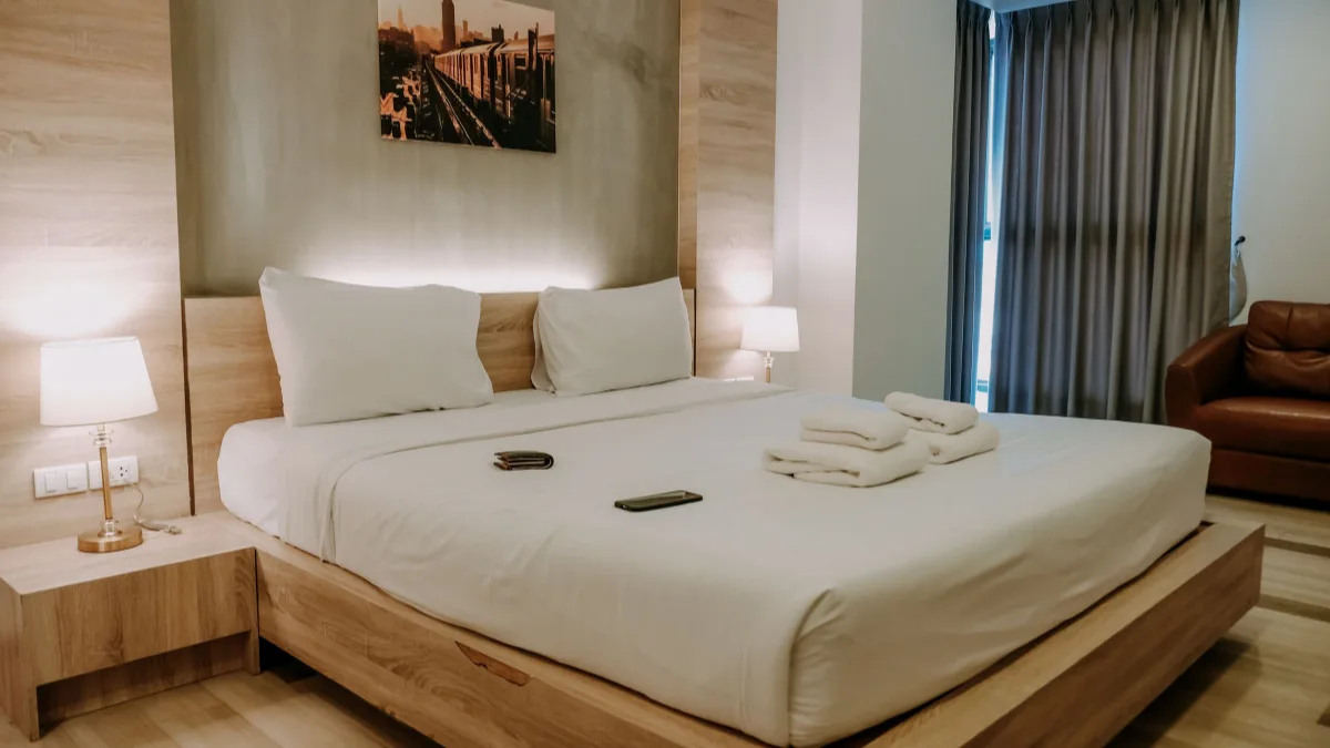 Freshly made bed with folded towels in a rental bedroom