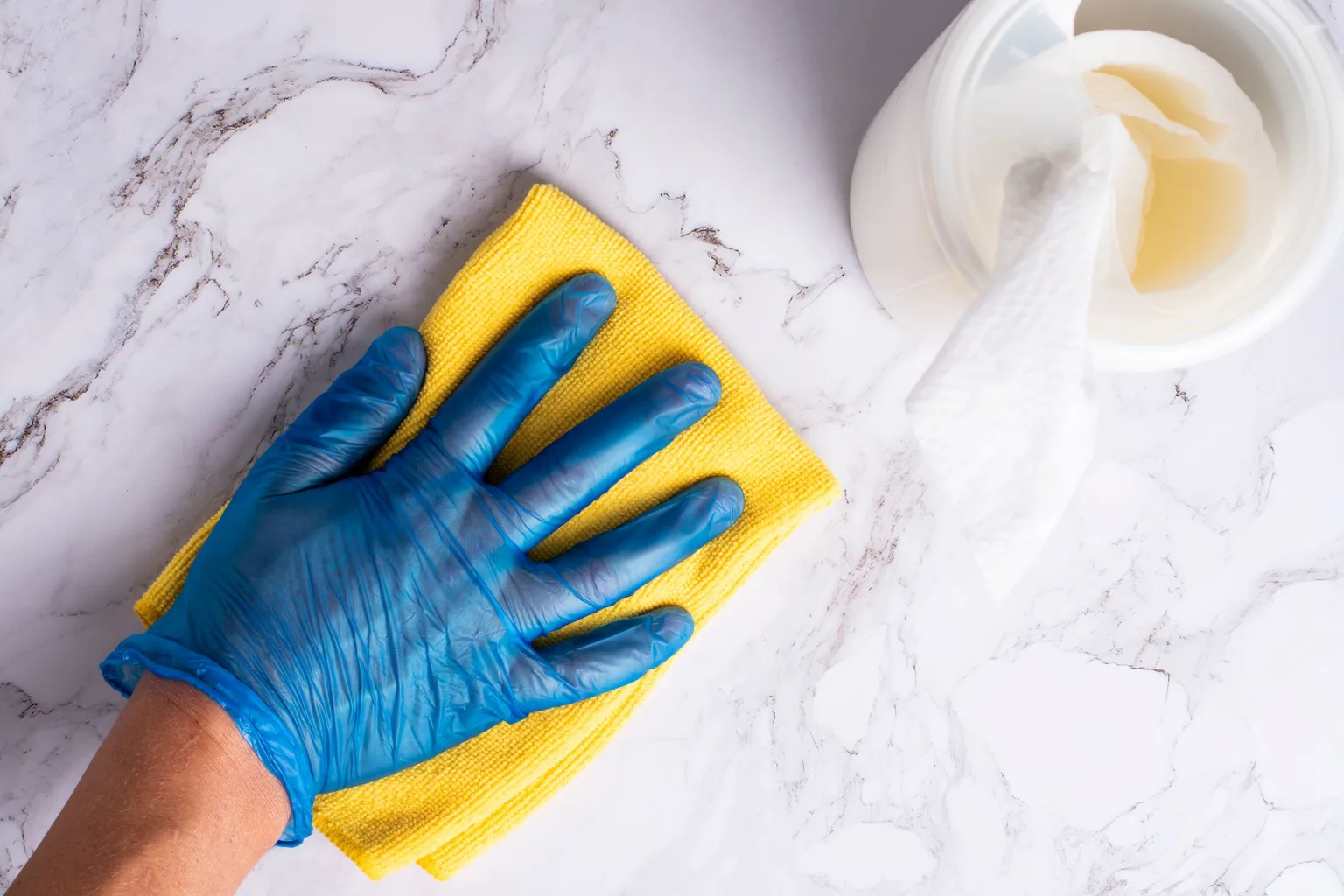 Gloved hand wiping a marble countertop