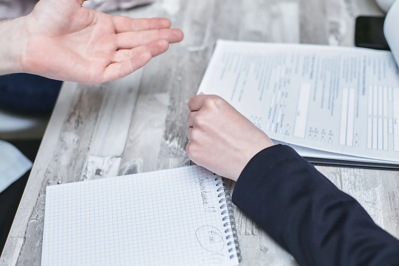 Hands reviewing paperwork at a desk