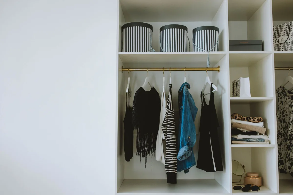 Neatly organized closet with hanging clothes and storage bins