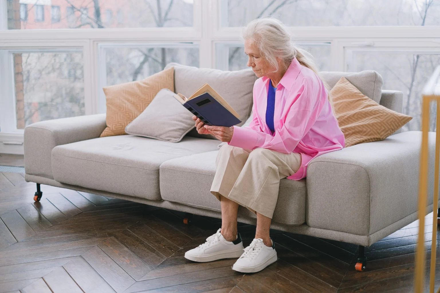 Senior woman reading on the sofa in a clean living room