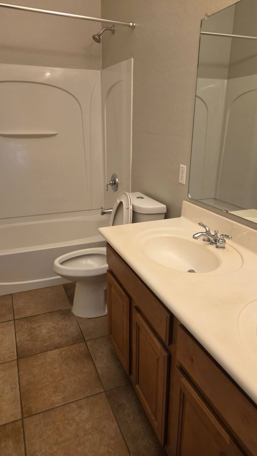 Clean bathroom with a white tub surround, toilet, and vanity after a house cleaning in Anthem, AZ