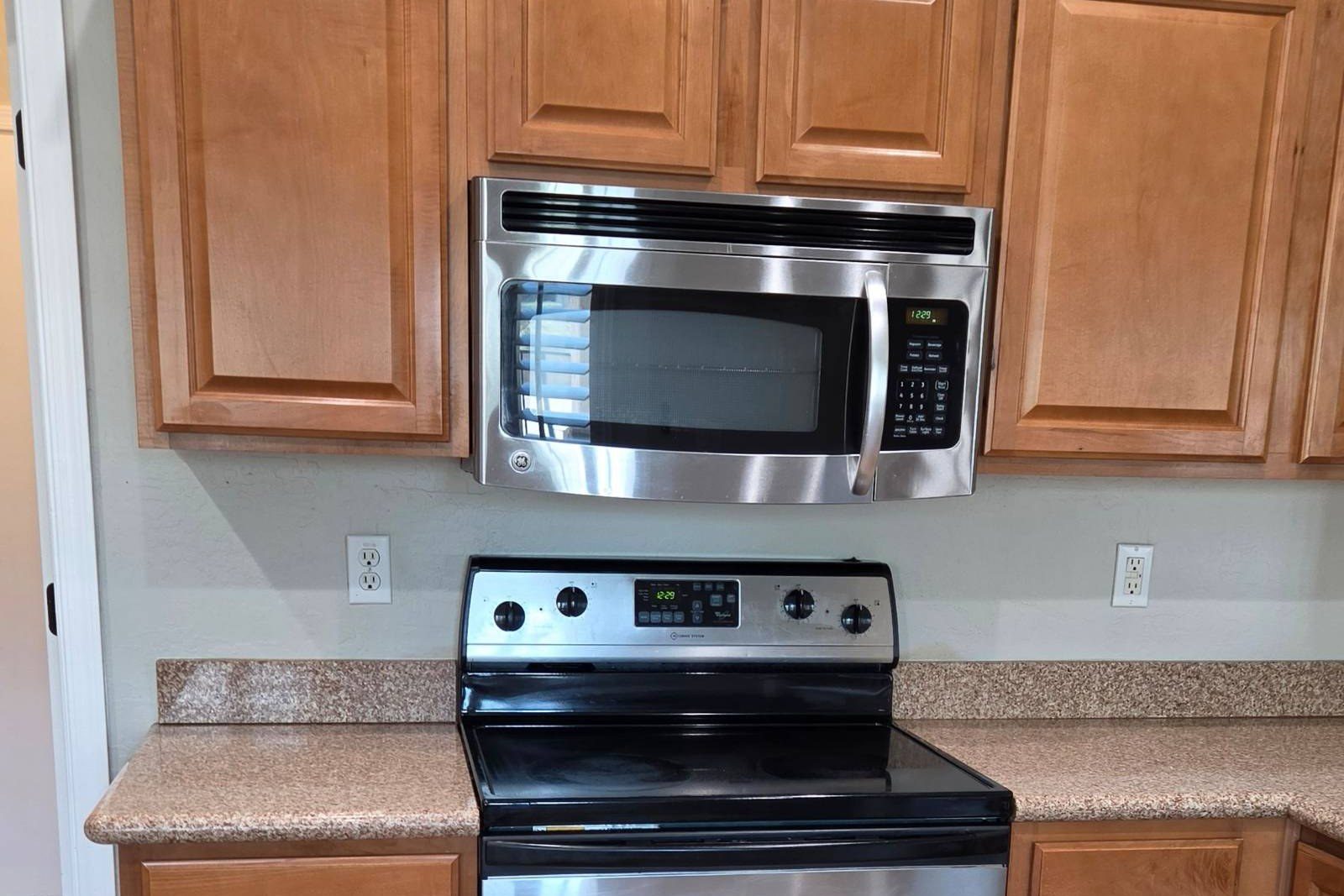Clean kitchen with wood cabinets, a stainless range, and a microwave after a house cleaning in Anthem, AZ