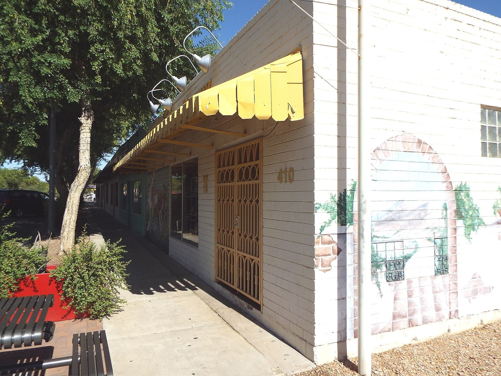 White historic storefront with a yellow awning and a painted mural in downtown Avondale, Arizona