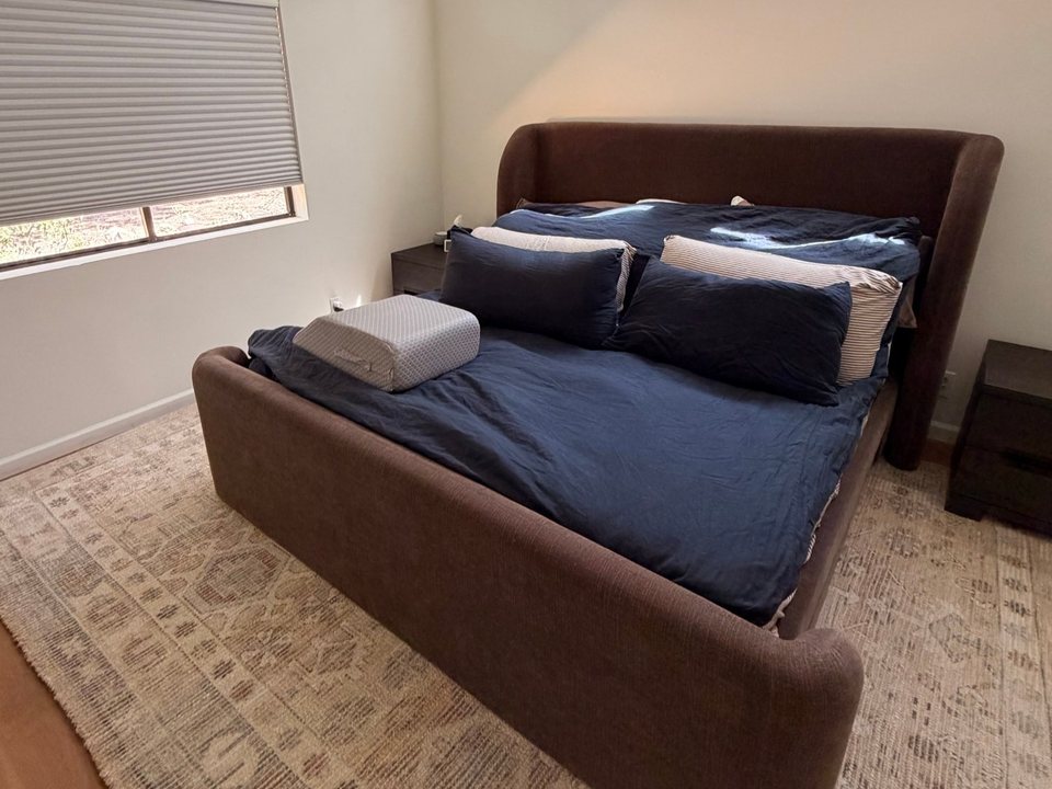 Same bed made with smooth navy bedding and stacked pillows after a cleaning in Flagstaff, AZ