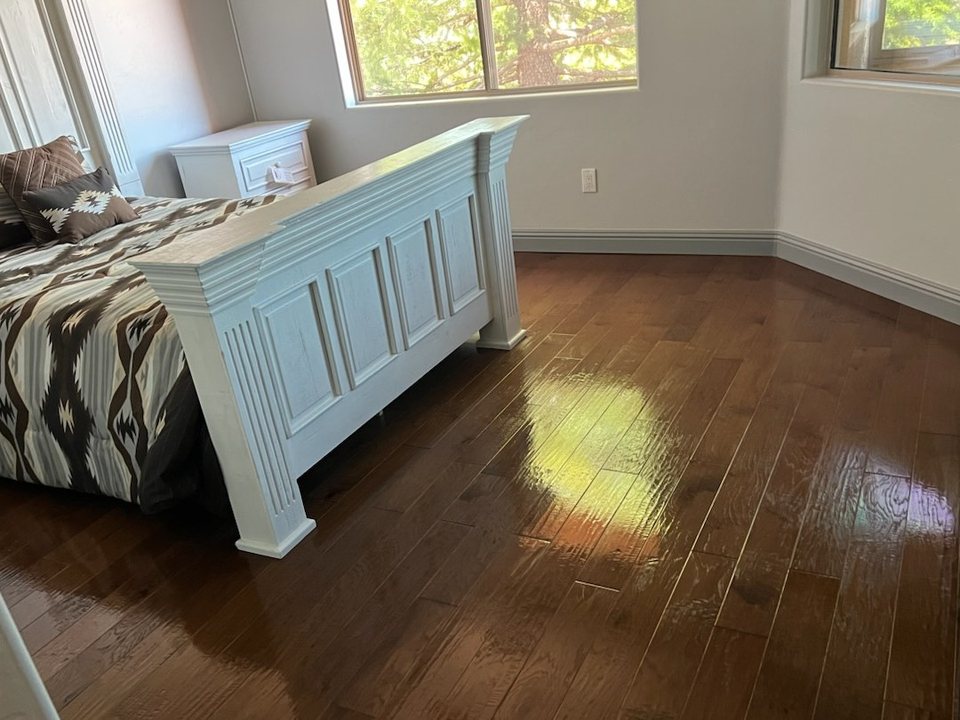 Same bedroom with a made bed and freshly mopped wood floors after a cleaning in Sedona, AZ