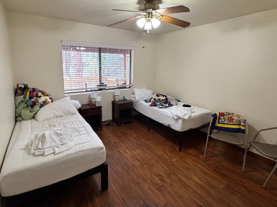 Bedroom with stripped beds and used linens piled up before a cleaning in Pine, AZ