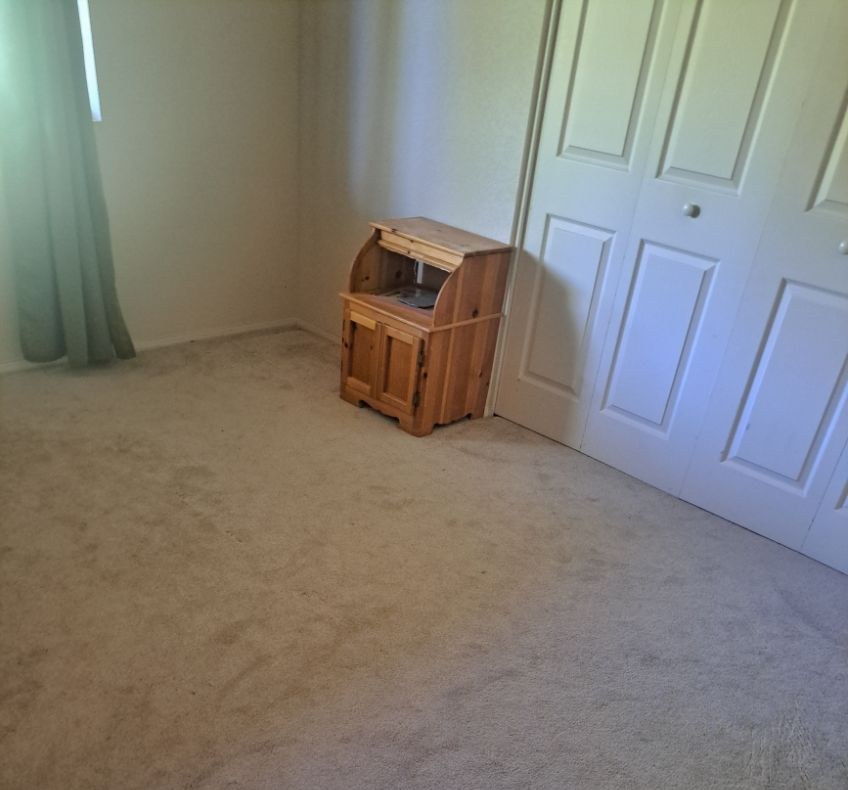 Bedroom with freshly vacuumed carpet and a small wooden desk after a house cleaning in Camp Verde, AZ