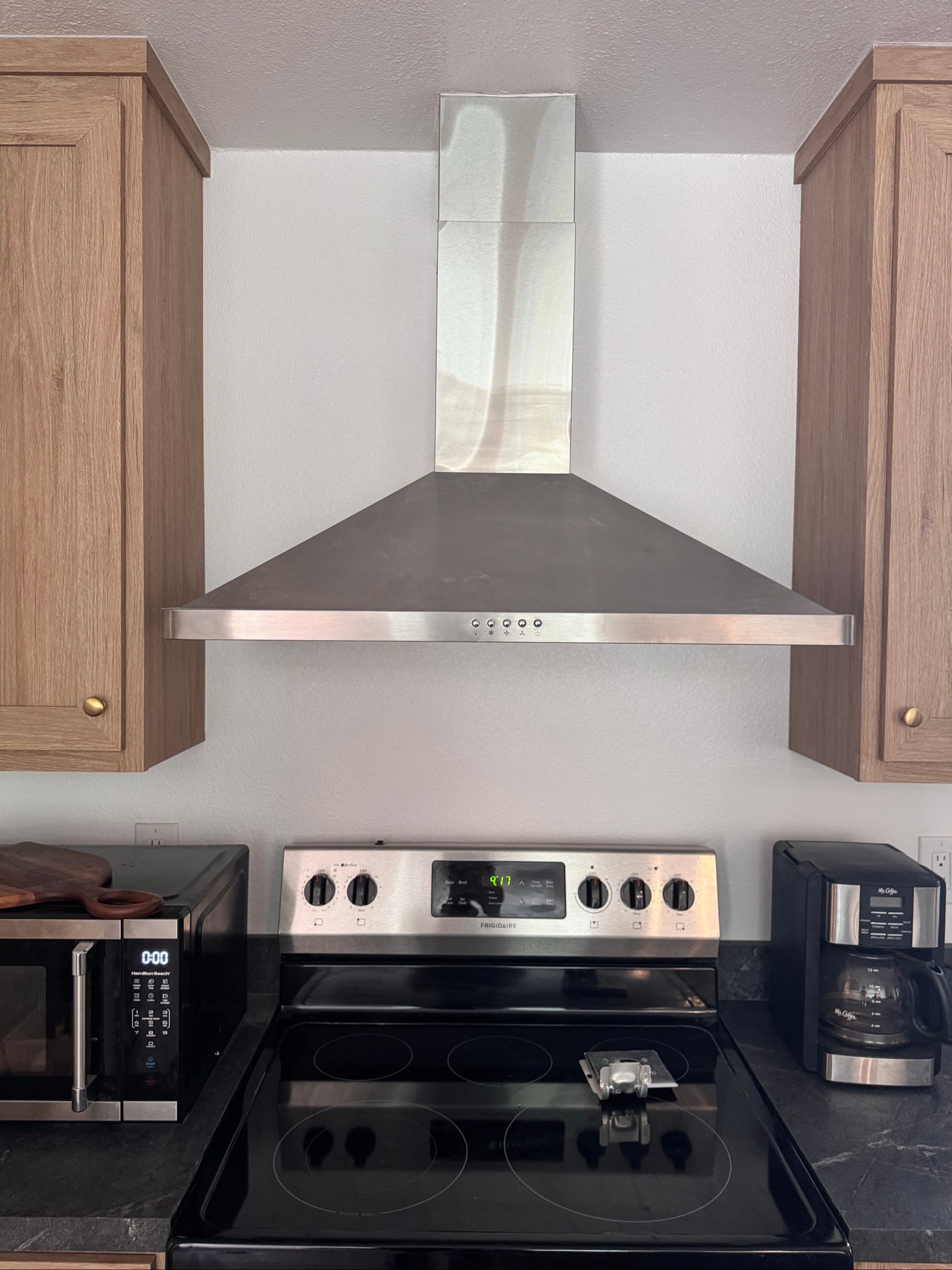 Clean glass cooktop and range hood between oak cabinets after a house cleaning in Camp Verde, AZ