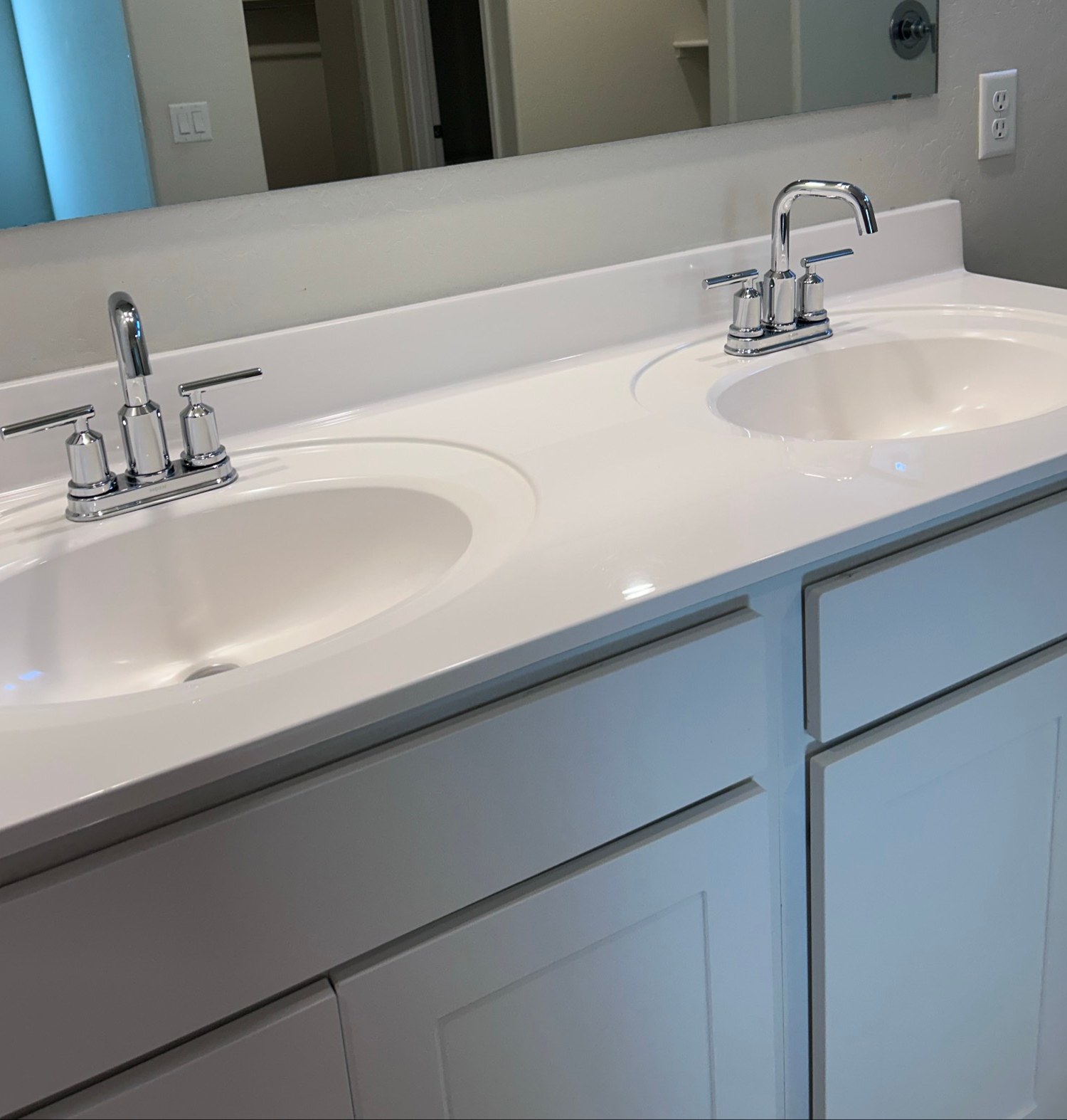 Clean white double sink bathroom vanity with chrome faucets after a house cleaning in Casa Grande, AZ