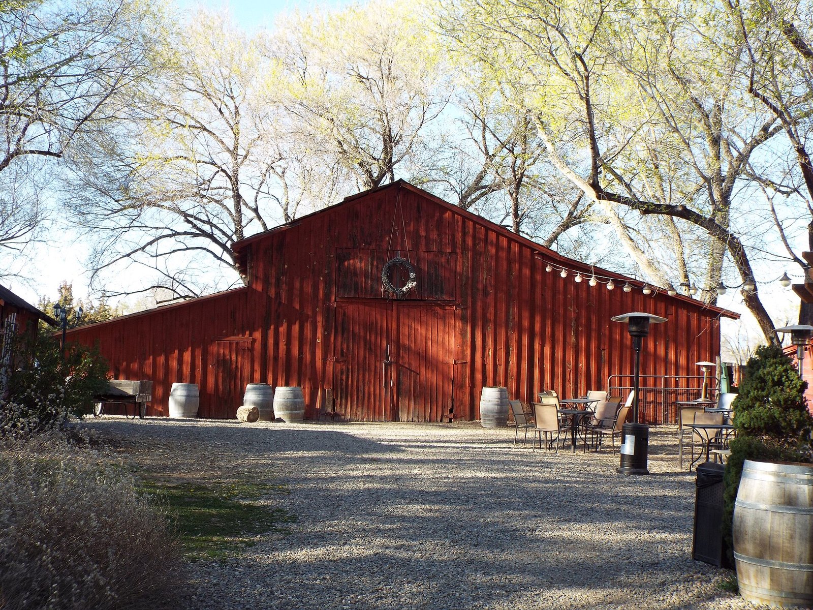 Red 1917 barn at Granite Creek Vineyards under bare trees in Chino Valley, Arizona