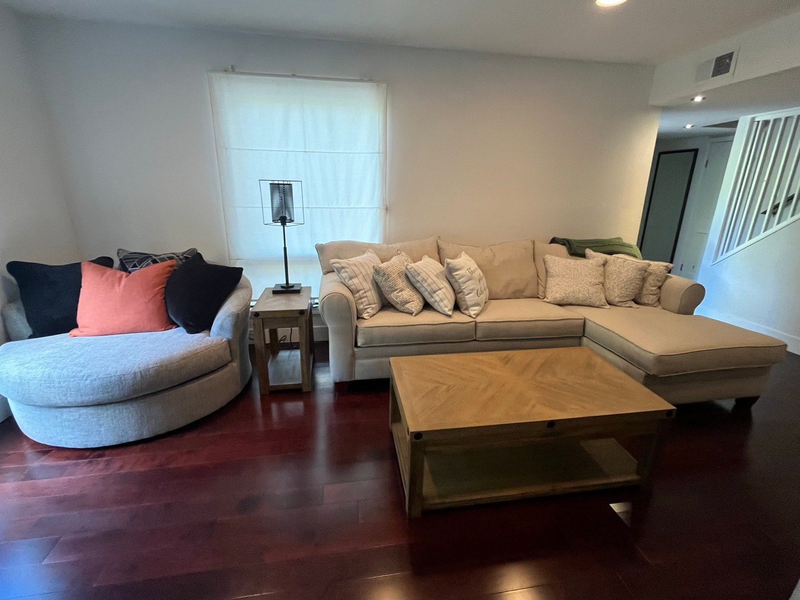 Tidy living room with fluffed sofa pillows and a shiny hardwood floor after a cleaning in Flagstaff, AZ