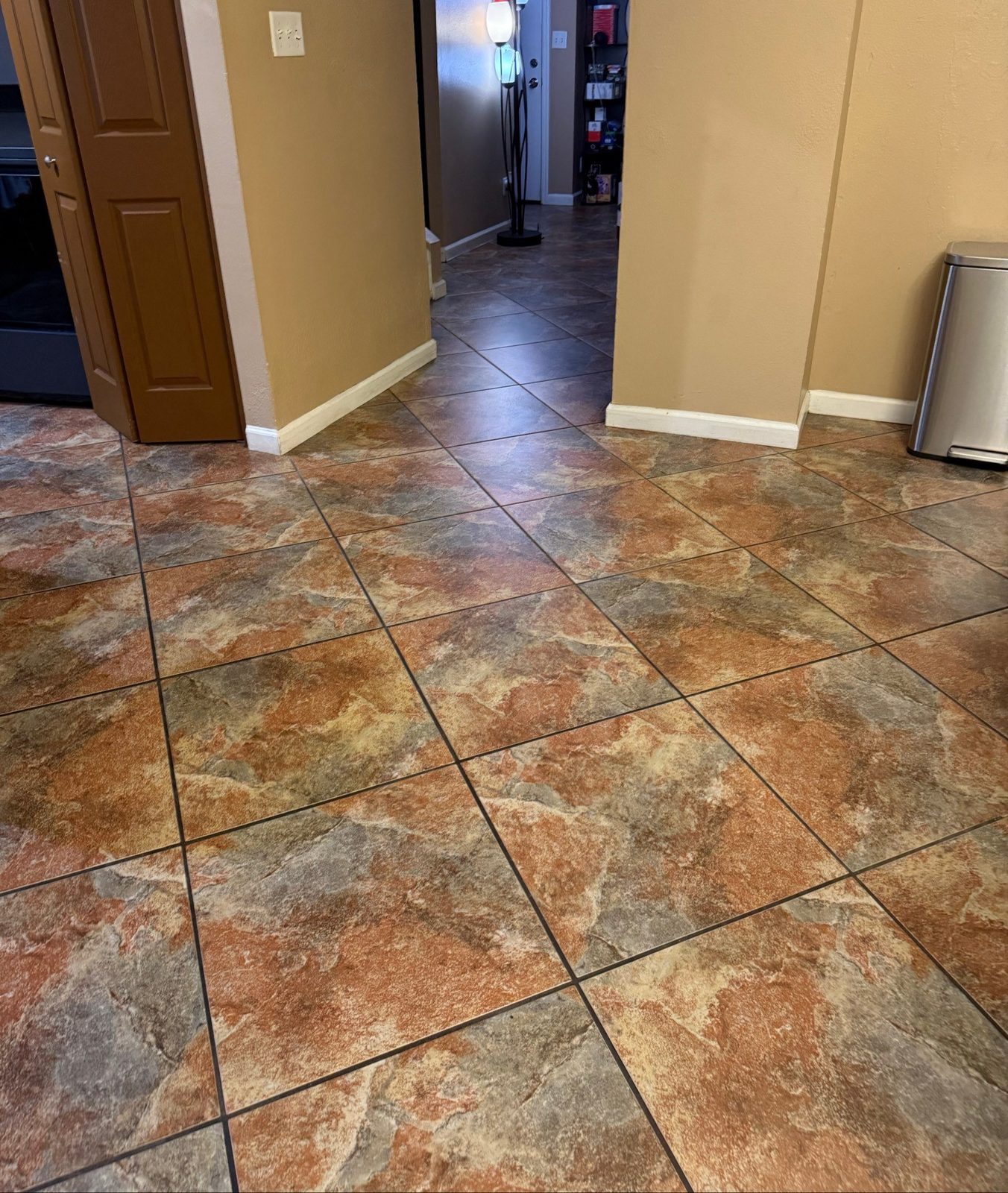 Clean stone-look tile floor leading into a hallway after a house cleaning in Glendale, AZ
