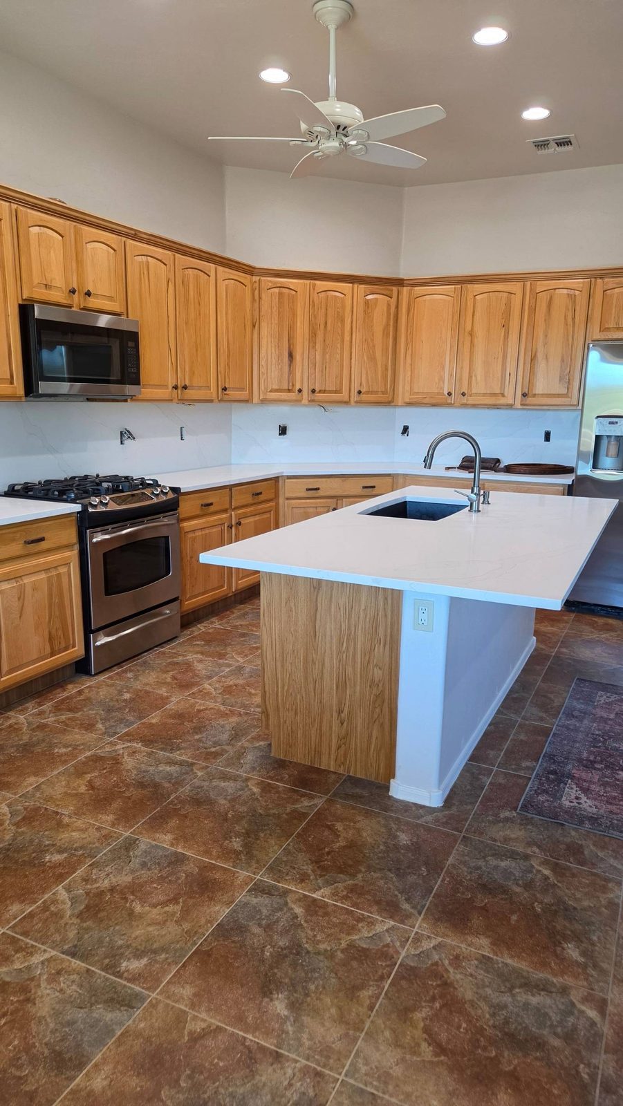 Clean kitchen with island, wood cabinets, and stainless appliances after a cleaning in Green Valley, AZ