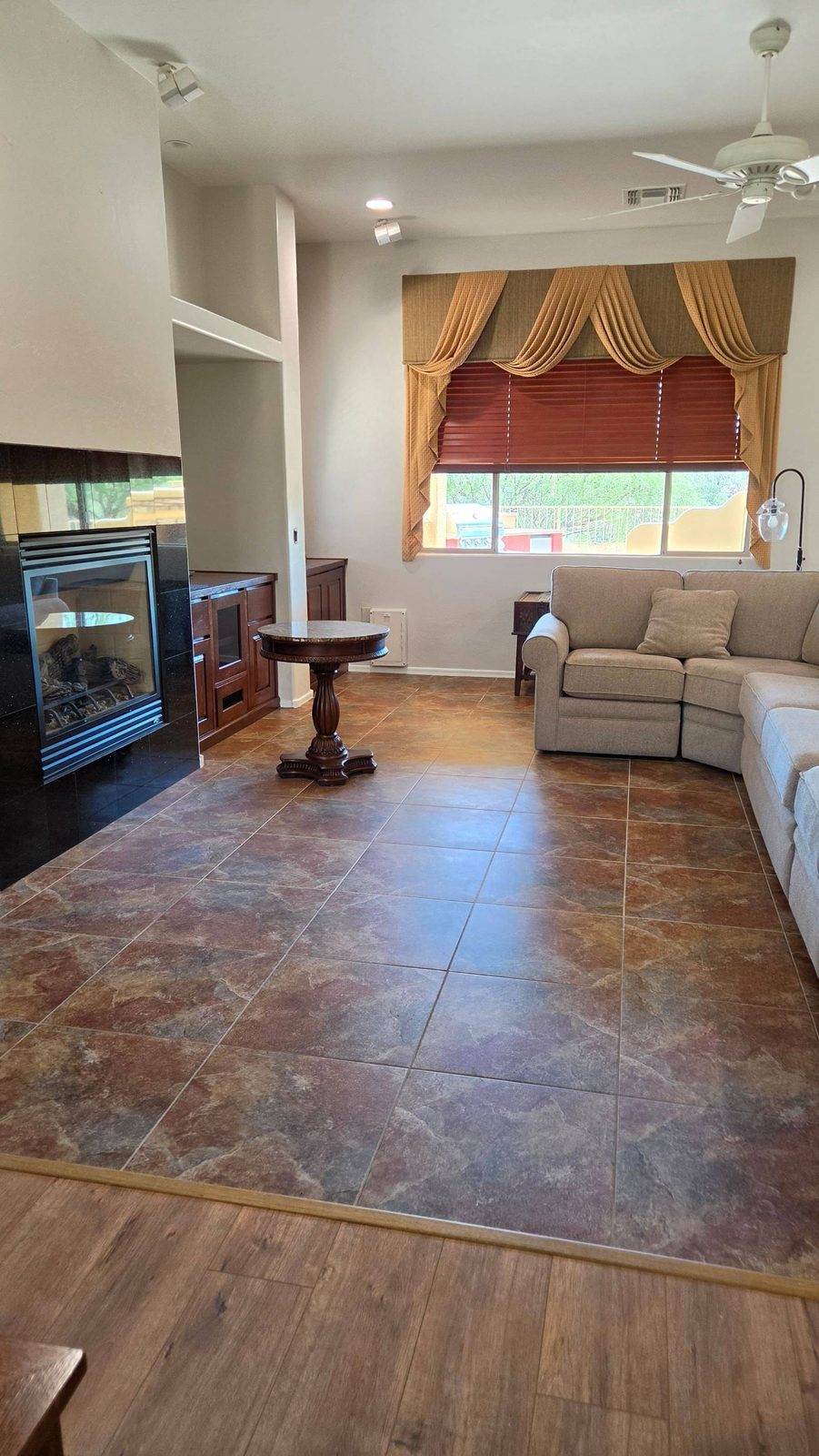 Living room with fireplace, sectional sofa, and clean tile floor in Green Valley, AZ