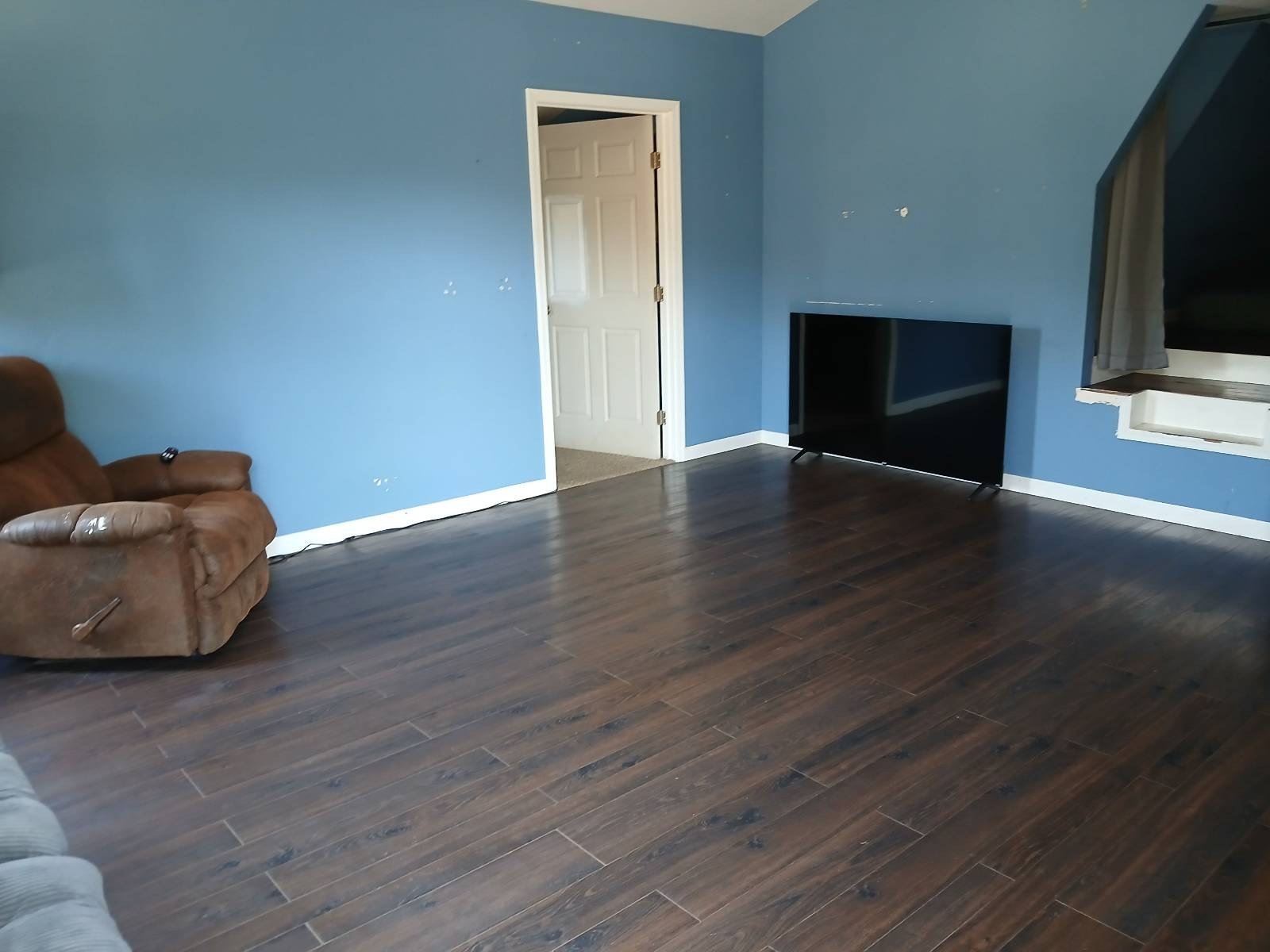 Living room with clean dark wood-look floors after a house cleaning in Dewey-Humboldt, AZ