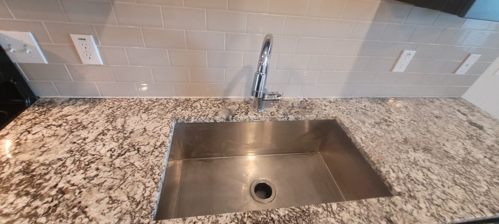 Clean stainless kitchen sink and granite counter after a move-out cleaning in Gilbert, AZ