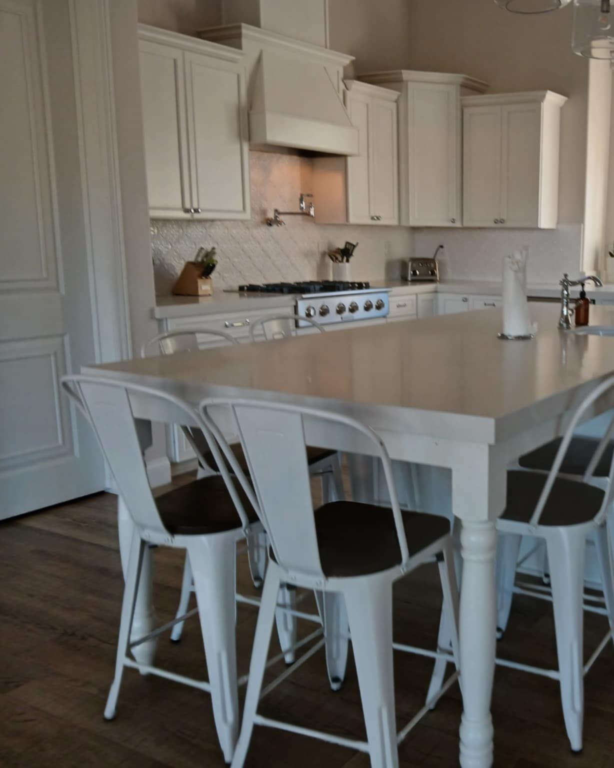 White kitchen with a clean island, bar chairs and wood floors after an Airbnb cleaning in Lake Havasu City, AZ