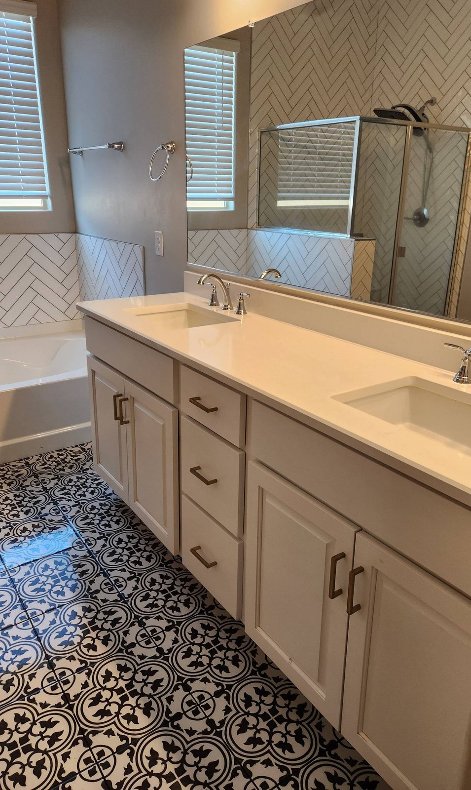 Bright bathroom with a clean double-sink vanity and black and white tile floor after a cleaning in Marana, AZ