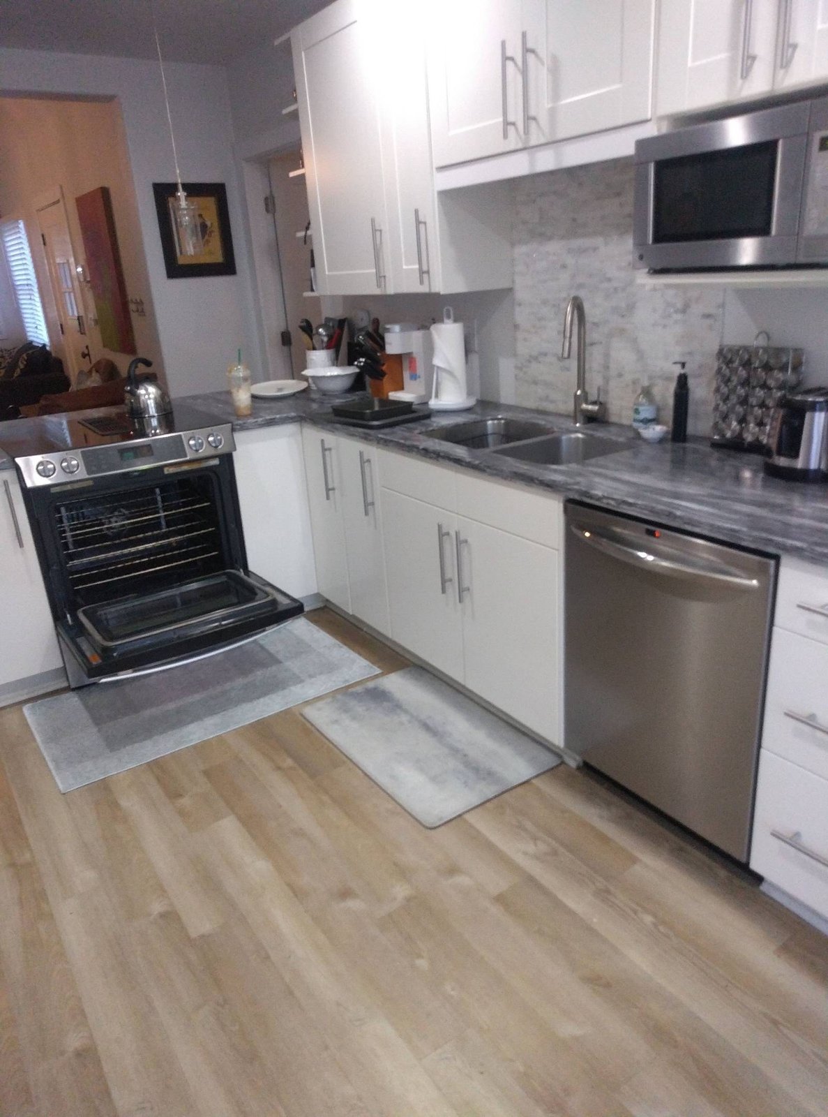 Clean white kitchen with stainless appliances and wood-look floor in Prescott, AZ