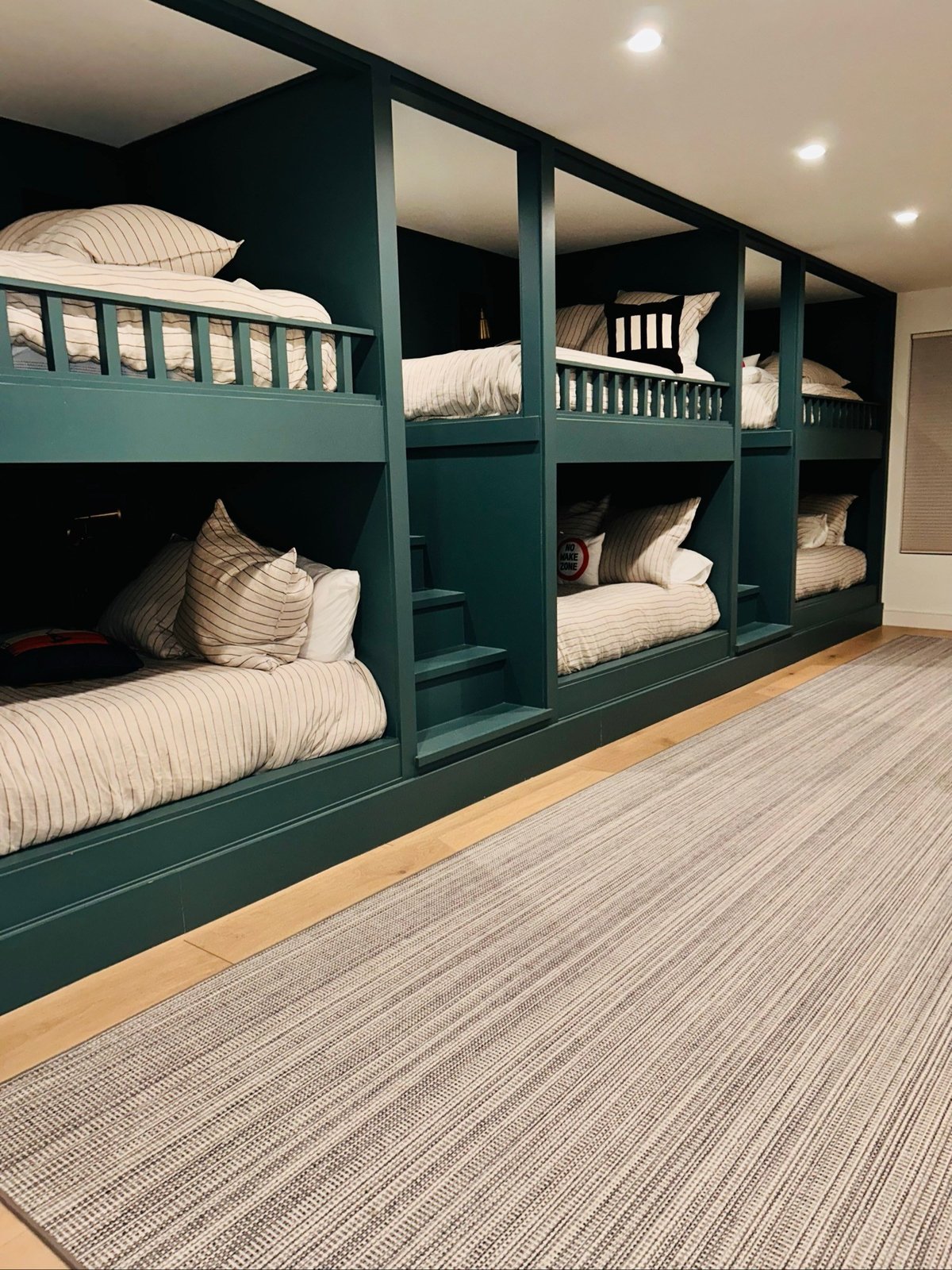 Built-in bunk beds with striped bedding and a clean runner rug in Yuma, AZ