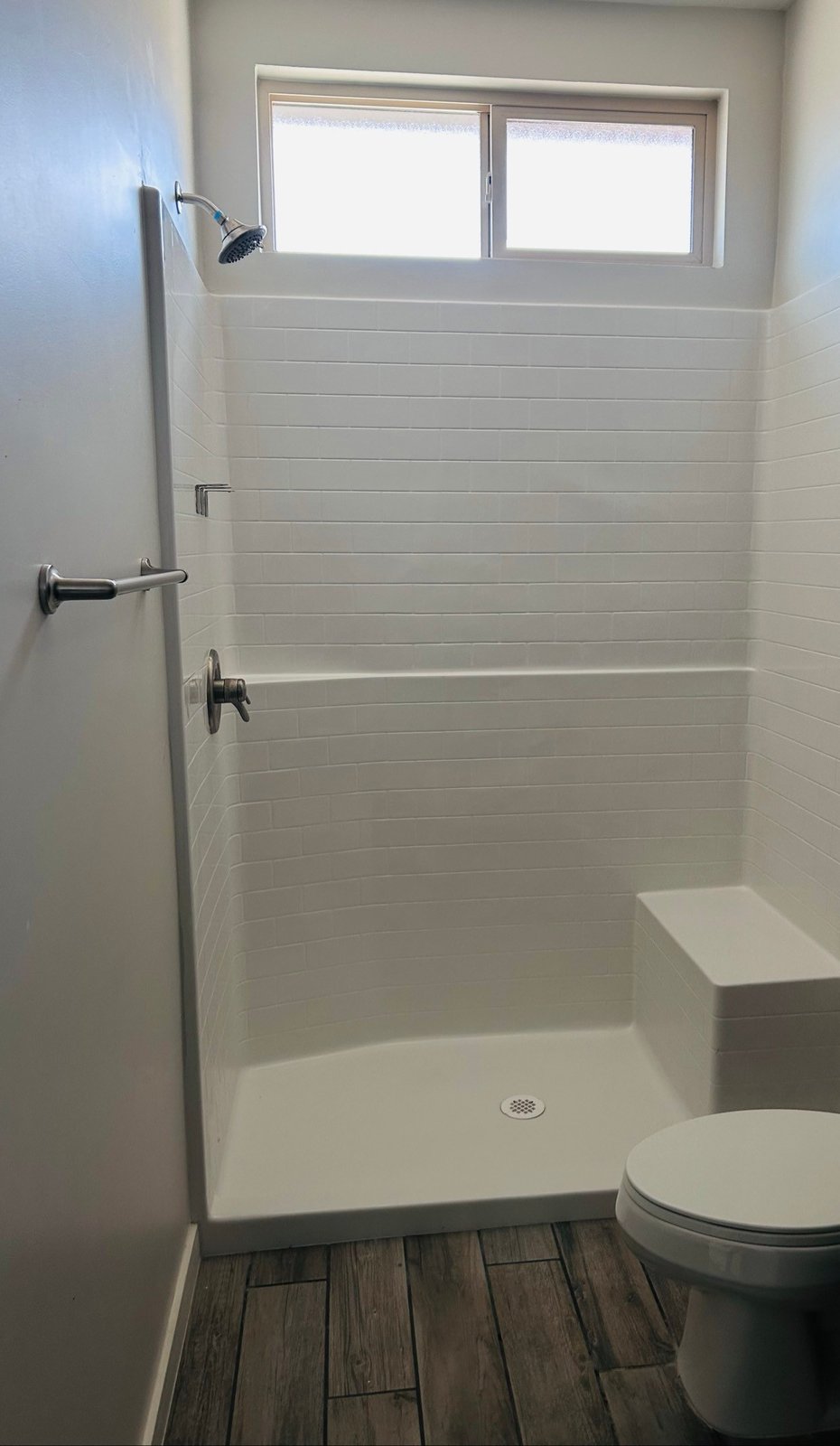 Clean bathroom with a white walk-in shower and seat after a cleaning in Yuma, AZ