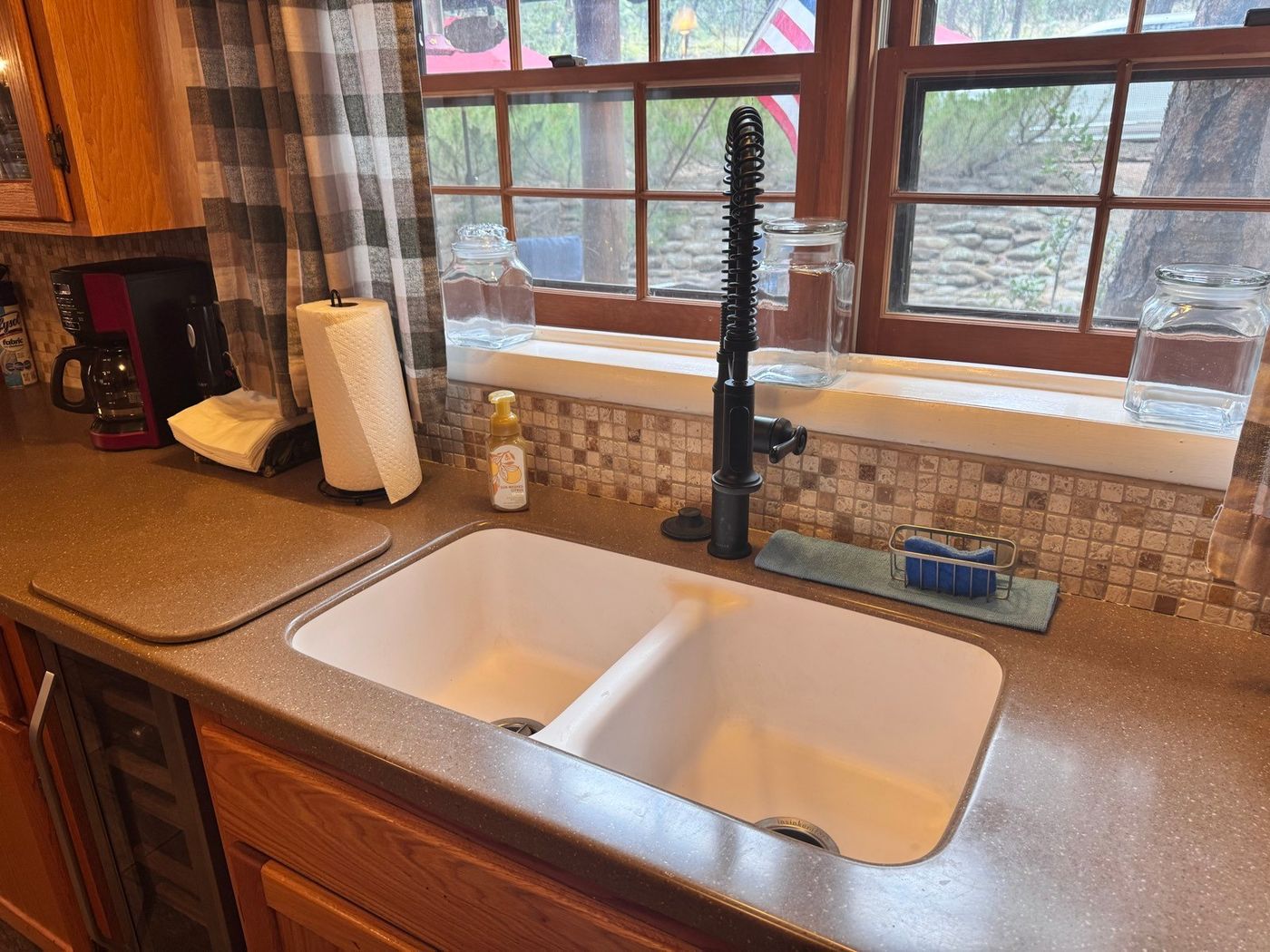 Clean double kitchen sink and counters under a window after a cabin cleaning in Pine, AZ