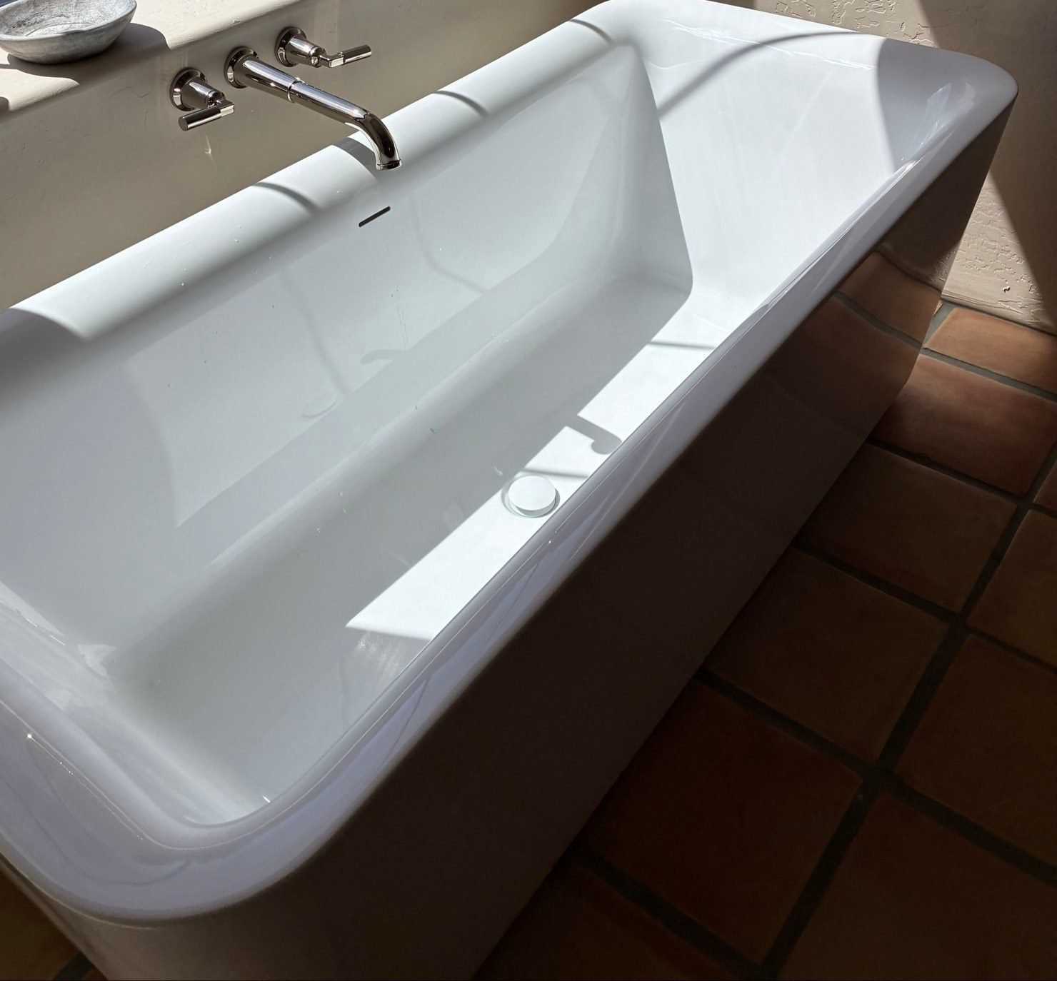 Clean white freestanding bathtub with a polished wall-mounted faucet after a post-construction cleaning in Prescott, AZ