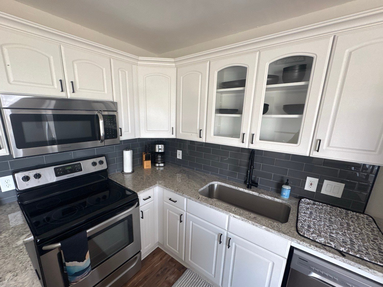Clean white kitchen with gray subway tile and stainless appliances after a cleaning in Prescott, AZ