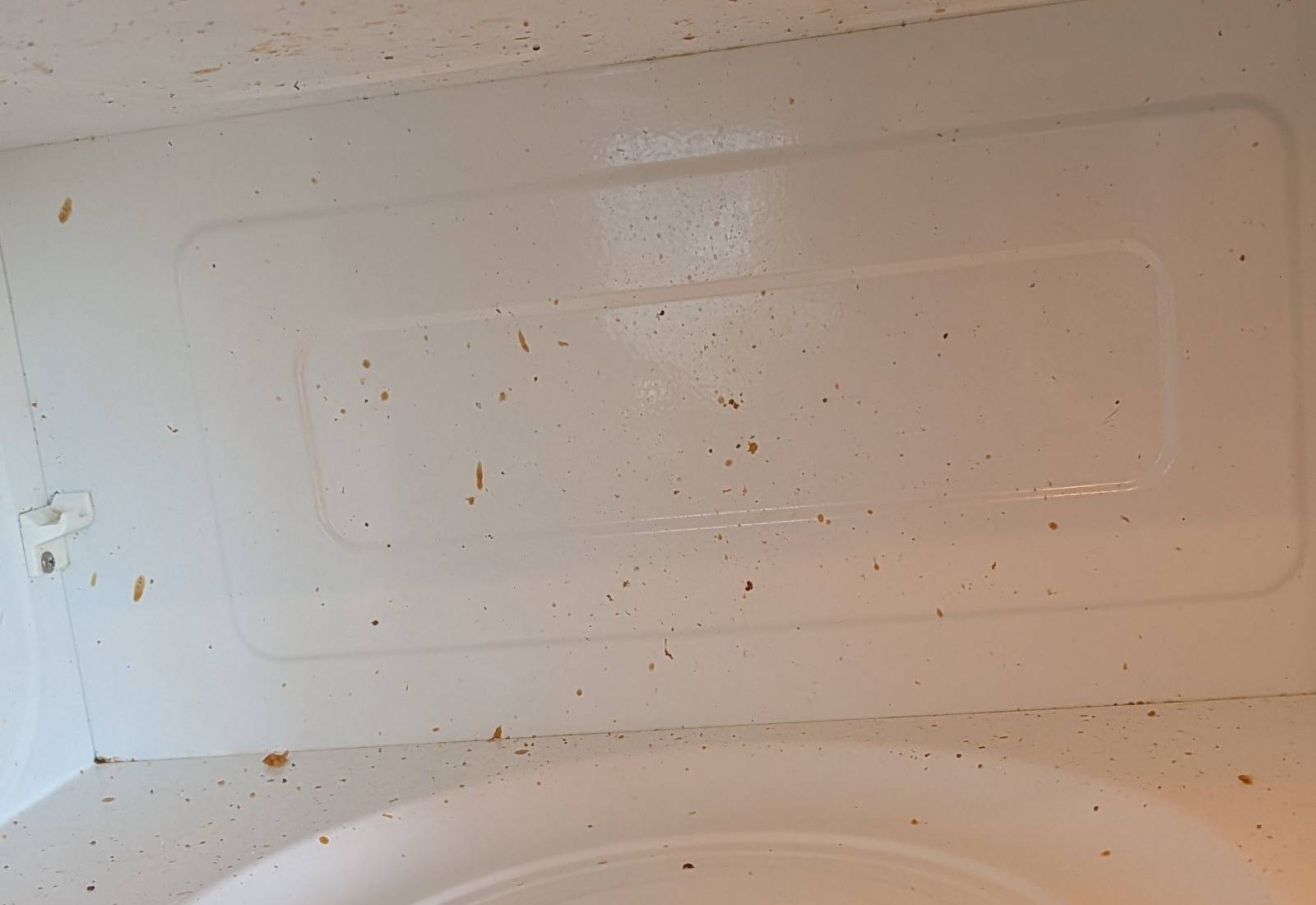 Microwave interior with dried food splatter on the walls and floor before a cleaning in Prescott, AZ