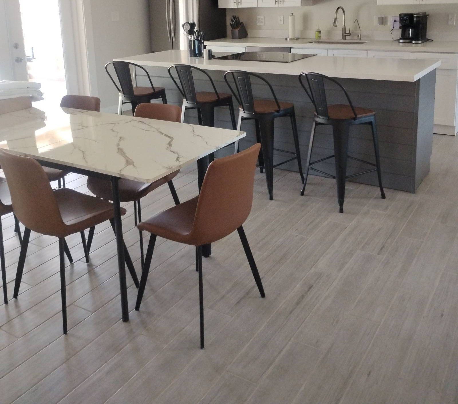Clean kitchen island with bar stools and a marble-look dining table after a house cleaning in Scottsdale, AZ