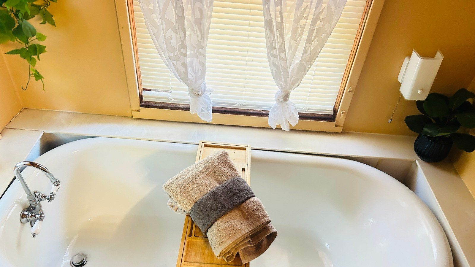 Clean white bathtub with folded towels on a wooden bath caddy after a cleaning in Sedona, AZ