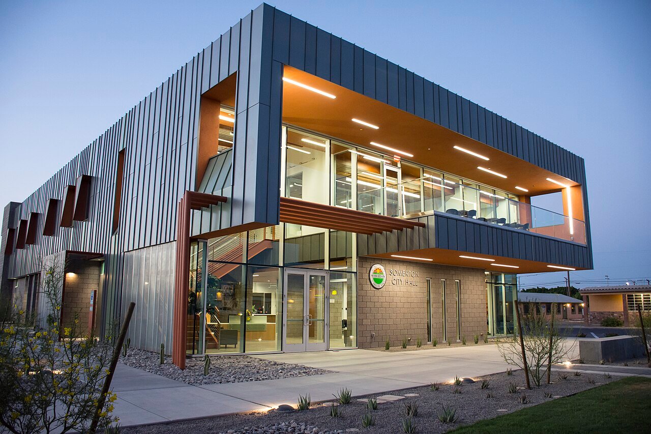 Modern two-story Somerton City Hall with glass walls at dusk in Somerton, Arizona
