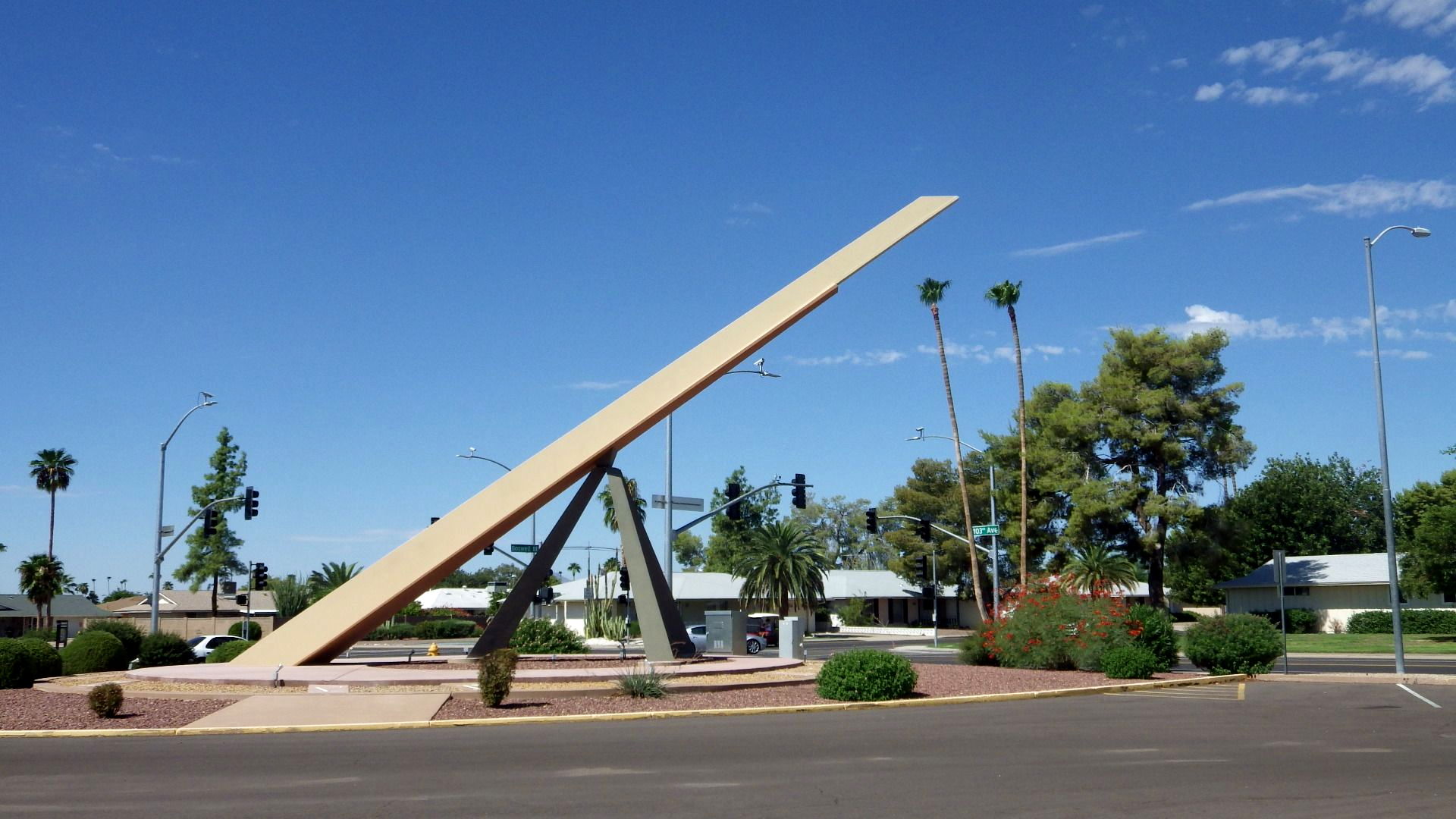 The Sun City Sundial, a large horizontal sundial at a Sun City, Arizona intersection, under a blue sky