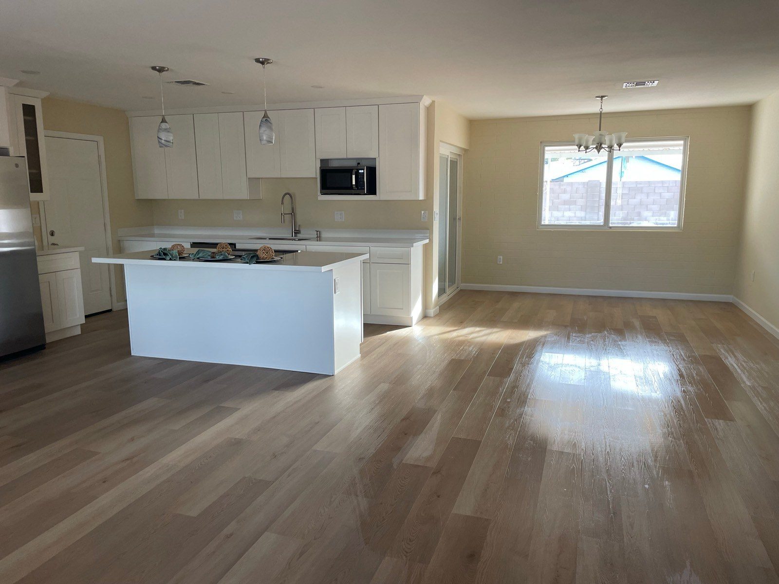 Open kitchen and great room with clean wood-look floors after a cleaning in Sun City, AZ