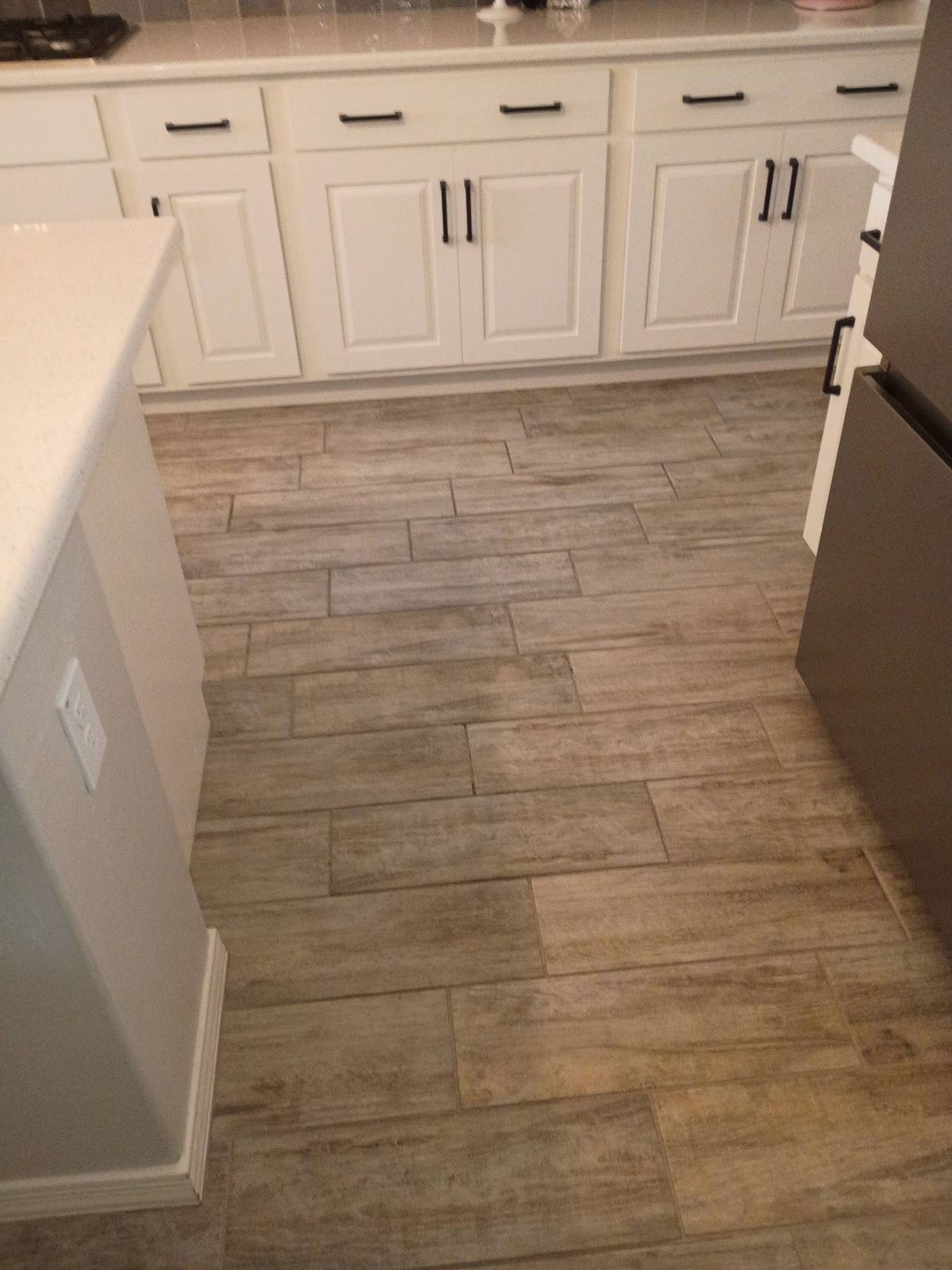 Clean wood-look tile kitchen floor between white cabinets in Surprise, AZ