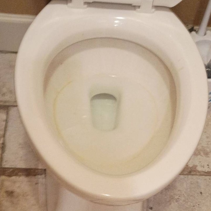 Toilet bowl with a yellow stain ring before cleaning in Black Canyon City, AZ