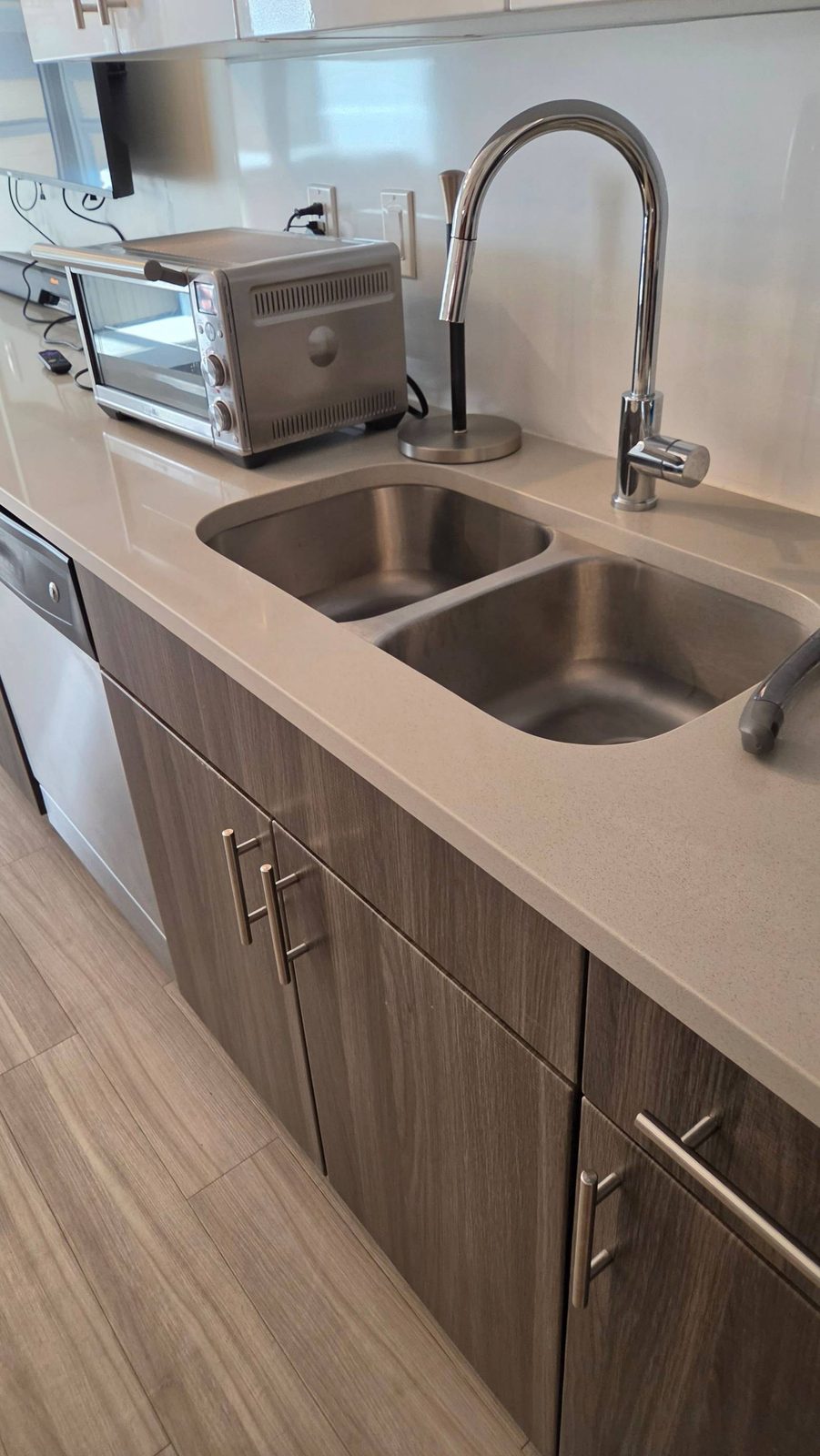 Clean stainless double sink and quartz counter in an apartment kitchen in Tucson, AZ