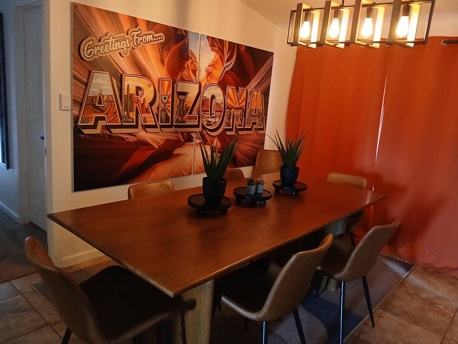 Polished dining table under a Greetings from Arizona mural in a Williams, AZ vacation rental
