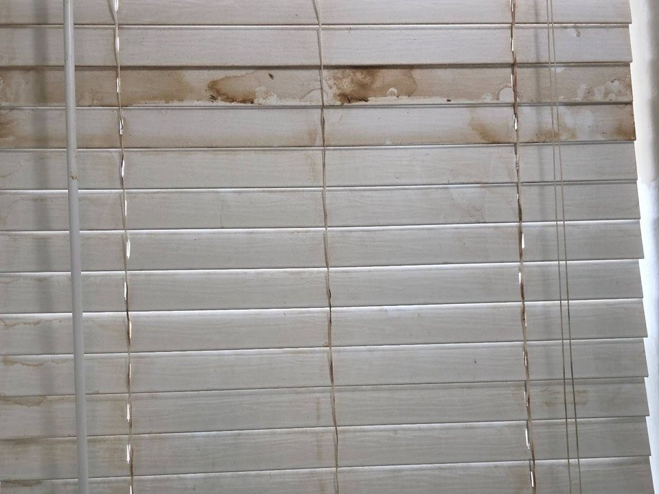 White window blinds with brown stains and grime on the slats before a cleaning in Lake of the Woods, AZ